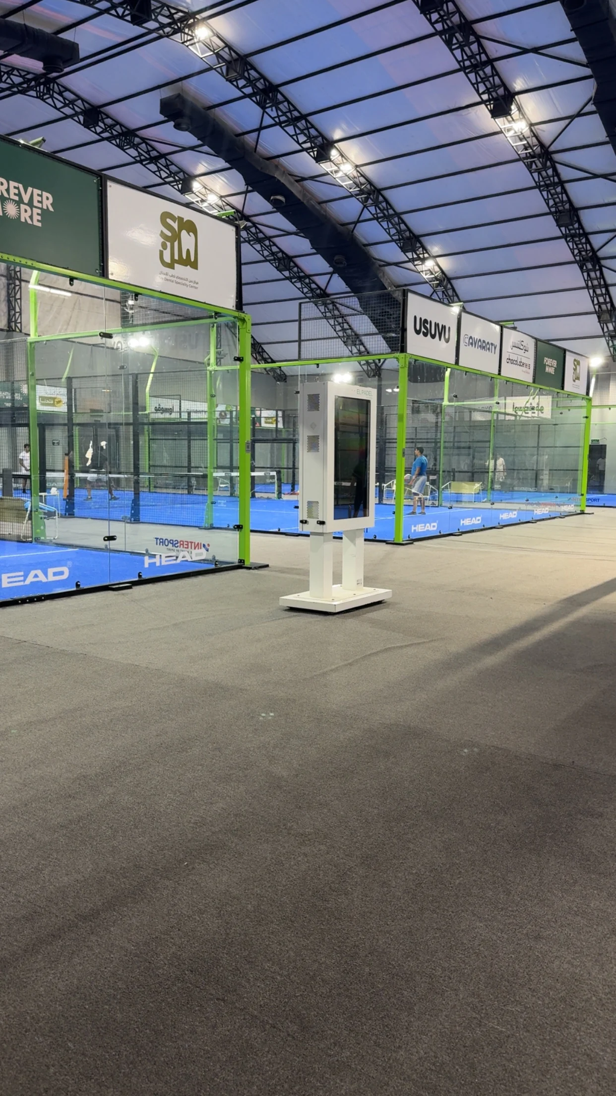 The covered indoor courts at El Padel Academy under the arched hall roof