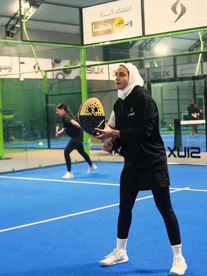 Two players in a rally on an indoor court